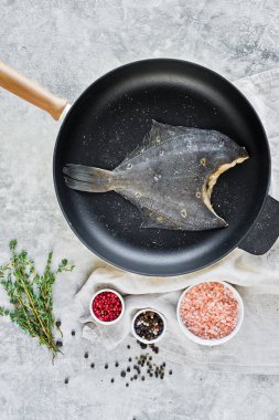 Pan çiğ pisi balığı. Gri arka plan, üstten görünüm.