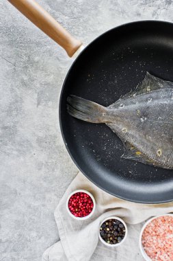 Pan çiğ yaldızlı pisibalığı. Gri arka plan, üstten görünüm.