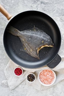 Pan çiğ yaldızlı pisibalığı. Gri arka plan, üstten görünüm.