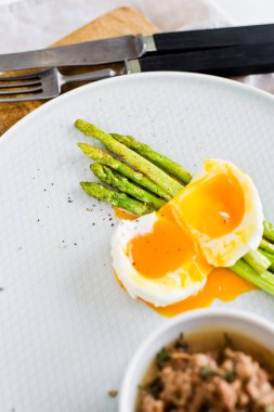 Yumurta ve ton balığı ile pişmiş mini kuşkonmamıza. Beyaz arka plan, üst görünüm.