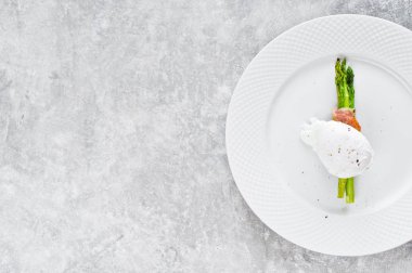 Pastırmalı kuşkonmamış yumurtalı yumurta. Gri arka plan, üst görünüm, metin alanı.