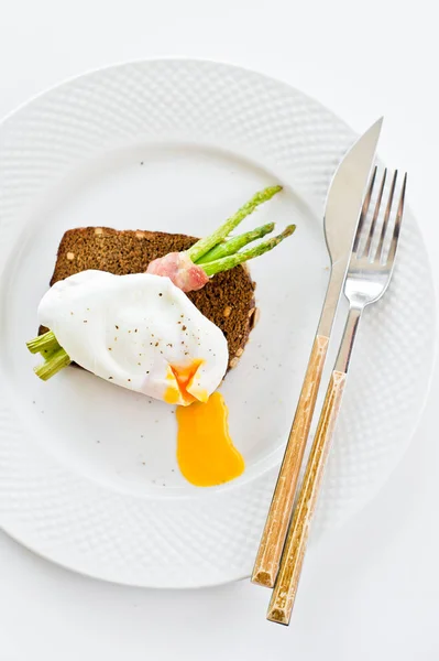 Sandwich aux œufs pochés et aux asperges cuites au four. Fond blanc, vue de dessus . — Photo