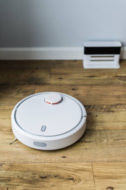 Ahşap zemine robot elektrikli süpürge. Üstteki görünüm. Akıllı ev konsepti. Otomatik temizlik