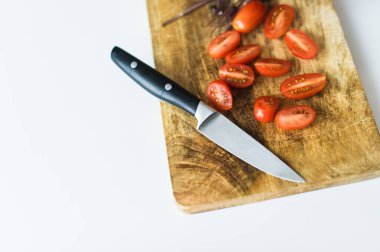 Kiraz domates ve Basil ahşap bir Doğrama Kurulu. Üstteki görünüm, beyaz arka plan.