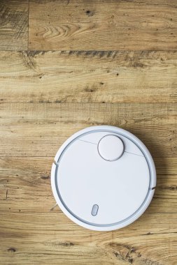 Ahşap zemine robot elektrikli süpürge. Üstteki görünüm. Akıllı ev konsepti. Otomatik temizlik