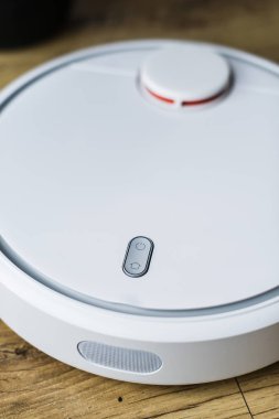 Ahşap zemine robot elektrikli süpürge. Yan görünüm. Akıllı ev konsepti. Otomatik temizlik.