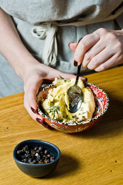 Aşçı kuzu bacağı için marinat hazırlar. Biberiye, keklik, karabiber. Siyah arka plan, yan görünüm, metin alanı