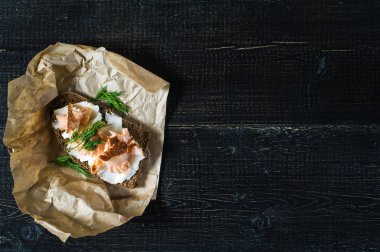 Yumuşak peynir ile siyah ekmek üzerinde füme somon fileto ile sandviç