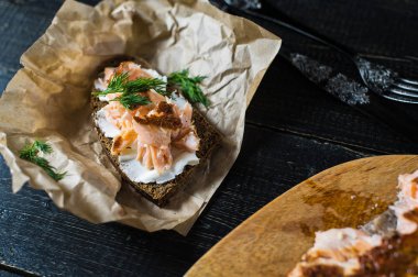 Yumuşak peynir ile siyah ekmek üzerinde füme somon fileto ile sandviç