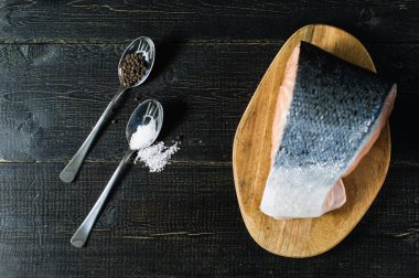 Atlantik çiğ somon, siyah ahşap arka planda biftek