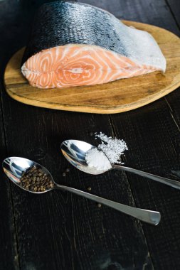 Atlantik çiğ somon, siyah ahşap arka planda biftek