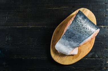 Atlantik çiğ somon, siyah ahşap arka planda biftek