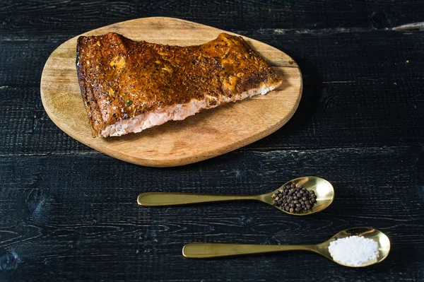 Siyah ahşap arka planda füme somon fileto.