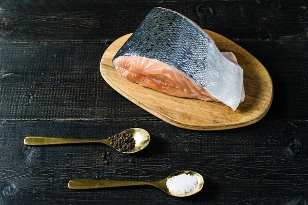 Atlantik çiğ somon, biftek a siyah ahşap arka plan üzerinde
