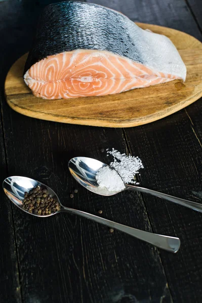Atlantik çiğ somon, siyah ahşap arka planda biftek