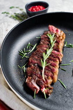 Mermer Sığır biftek siyah Angus kavurma arka bir Pan. Gri arka plan, üst görünüm.