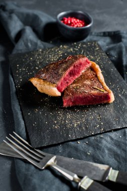 Sığır eti bifteği, kavrulmuş arka. Siyah arka plan, üst görünüm.
