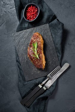 Biberiye ile Beef rampa biftek. Siyah arka plan, üst görünüm.