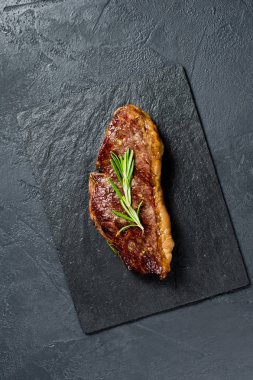 Biberiye ile Beef rampa biftek. Siyah arka plan, üst görünüm.