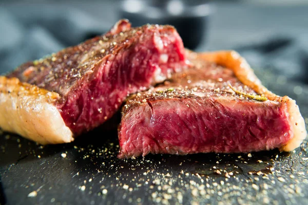 Beef sirloin steak, roasted rear. Black background, top view.