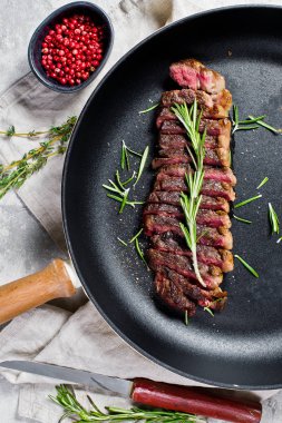 Mermer Sığır biftek siyah Angus kavurma arka bir Pan. Gri arka plan, üst görünüm.