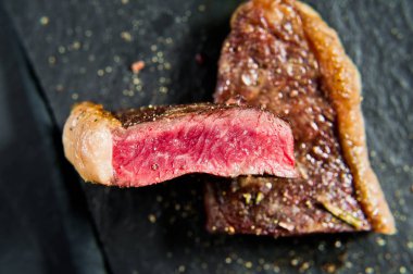 Biftek mermer Beef siyah Angus kavrulmuş arka. Siyah arka plan, üst görünüm.