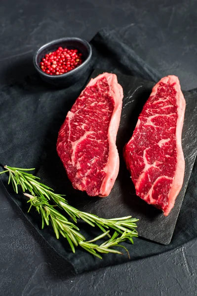 Steak de bœuf marbré Angus noir. Fond noir, vue de dessus . — Photo