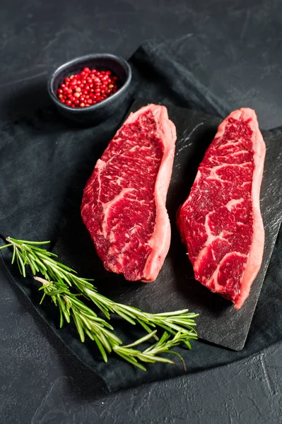 Steak a márványos marha Fekete Angus. Fekete háttér, felülnézet. — Stock Fotó