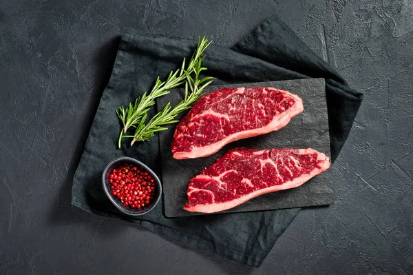 Steak z marinovaná hovězí černé Angusi. Černé pozadí, pohled shora. — Stock fotografie
