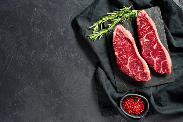 sirloin a raw beef steak. Black background, top view.