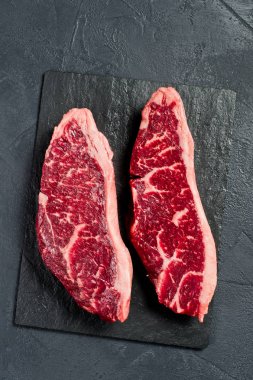 Çiğ sığır rampası bifteği. Siyah arka plan, üst görünüm.