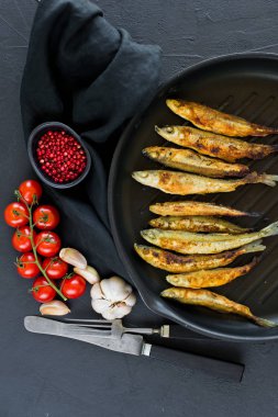 Tavada kızartılmış bir koku. Siyah arka plan, üst görünüm, metin için alan.