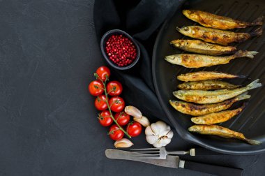 Tavada uskumru kızartılmış. Siyah arka plan, üst görünüm, metin için alan