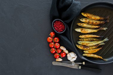 Tavada kızartılmış bir koku. Siyah arka plan, üst görünüm, metin için alan.