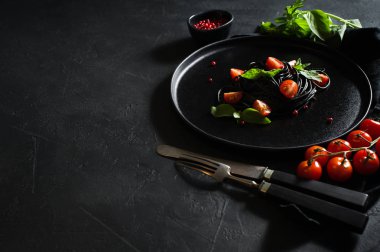 Mürekkep balığı mürekkesi olan siyah spagetti. Siyah arka plan, üst görünüm, metin için alan