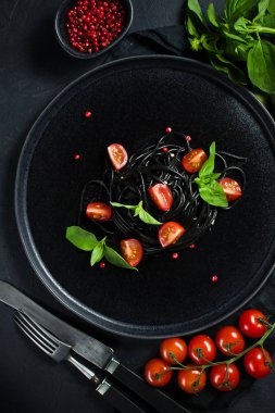 Mürekkep balığı mürekkesi olan siyah spagetti. Siyah arka plan, üst görünüm, metin için alan