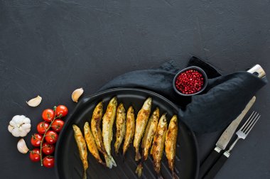 Tavada kızartılmış bir koku. Siyah arka plan, üst görünüm, metin için alan.