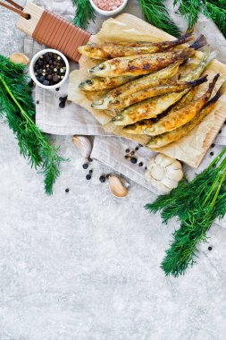 Kızarmış bir tahta doğrama Tahtası, dereotu, pembe tuz, biber ve sarımsak üzerinde eritilir. Gri arka plan, üst görünüm, metin için alan.