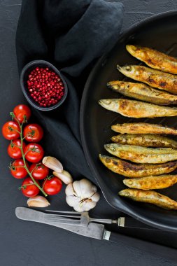 Tavada uskumru kızartılmış. Siyah arka plan, üst görünüm, metin için alan