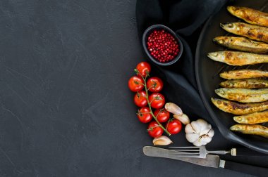 Tavada uskumru kızartılmış. Siyah arka plan, üst görünüm, metin için alan