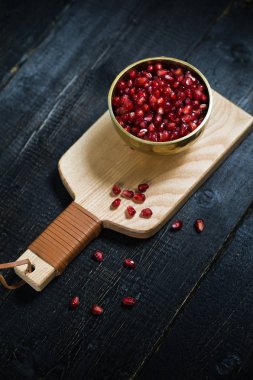 Ahşap kesme Tahtası üzerinde bir kase içinde Nar çekirdekleri.