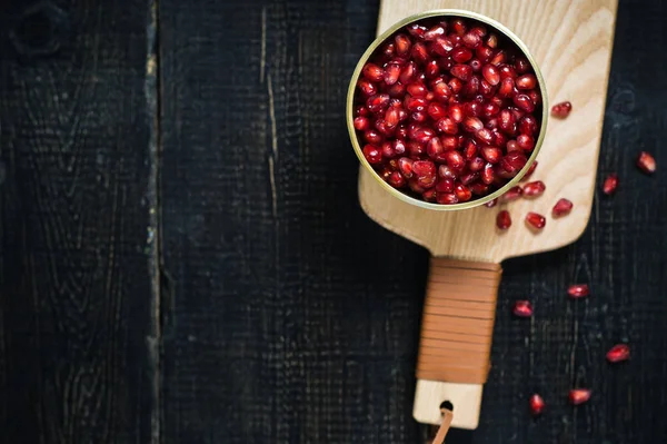 Granaatappel kernels in een kom op een houten snijplank. — Stockfoto