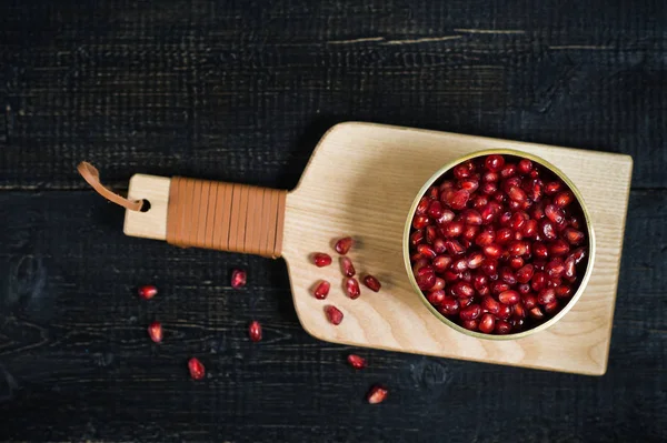 Granaatappel kernels in een kom op een houten snijplank. — Stockfoto