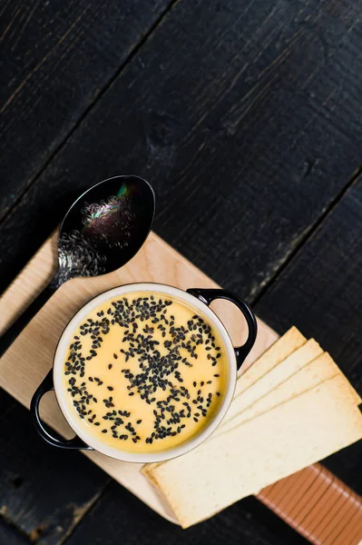 Sopa de abóbora com gergelim preto e biscoitos . — Fotografia de Stock