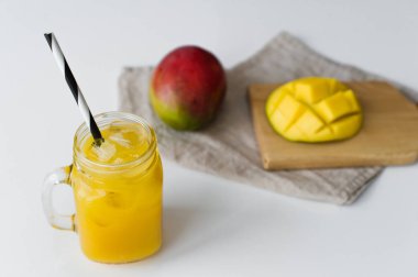 Olgun mango, yarım mango ve ahşap doğrama Tahtası üzerinde mango suyu bir bardak.