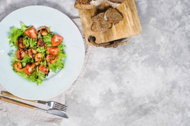 Dengeli sağlıklı gıda, ızgara karides ve balsamik altında kiraz domates ile yeşil salata.