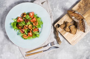 Izgara karides ve ekmek ile ahşap kesme Kurulu ile Yeşil salata.