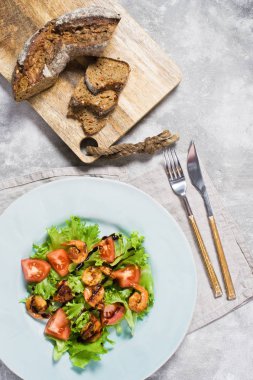 Izgara karides ve ekmek ile ahşap kesme Kurulu ile Yeşil salata.