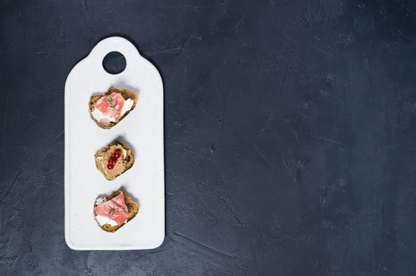 Brinde com Parma, salame e paté de ganso em uma tábua de corte branco — Fotografia de Stock