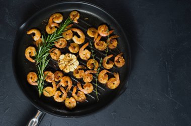 Kızarmış kral karides ve biberiye ve kekik sprigs ile kızartma tavası.